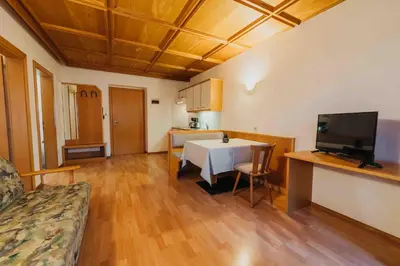 a living room with a table and a kitchen at Appartements Elke in Lagundo
