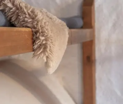 a stuffed animal on the side of a wooden chair at B&B Öboluckna in Molini di Tures
