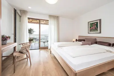 a bedroom with two beds and a desk and a chair at Ferienwohnung in Schenna mit Bergblick und Pool - Unterpenatz in Schenna