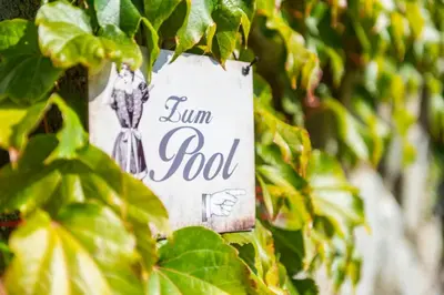 a sign attached to a tree with green leaves at Ferienwohnung in Schenna mit Bergblick und Pool - Unterpenatz in Schenna