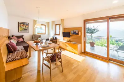 a living room with a table and a couch at Ferienwohnung in Schenna mit Bergblick und Pool - Unterpenatz in Schenna