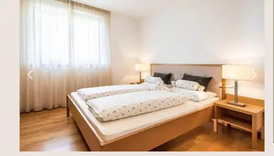 a bedroom with a large bed and a window at Ferienwohnung in Schenna mit Bergblick und Pool - Unterpenatz in Schenna