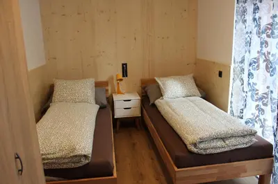 a room with two beds and a night stand with a table at Apartment Claudia in Bressanone