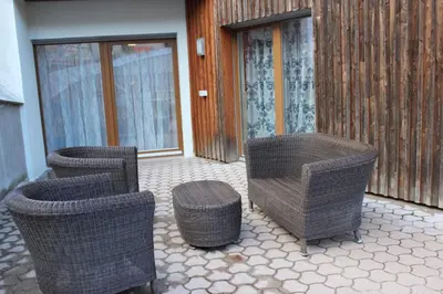 a group of wicker chairs andools on a patio at Apartment Claudia in Bressanone