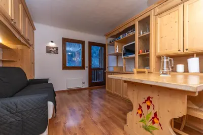 a kitchen with wooden cabinets and a counter top at Suite Monte Pelsa in Alleghe