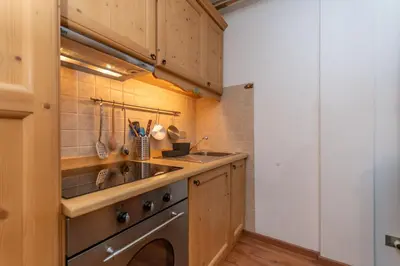 a kitchen with a sink and a washing machine at Suite Monte Pelsa in Alleghe