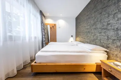 a bedroom with a large white bed and a large window at CHALET ARIA Stay Mountain Relax in Arabba