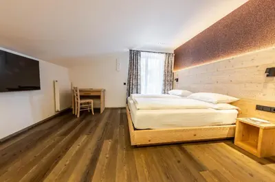 a bedroom with a bed and a desk and a television at CHALET ARIA Stay Mountain Relax in Arabba