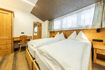 a bedroom with a large white bed and a desk at CHALET ARIA Stay Mountain Relax in Arabba