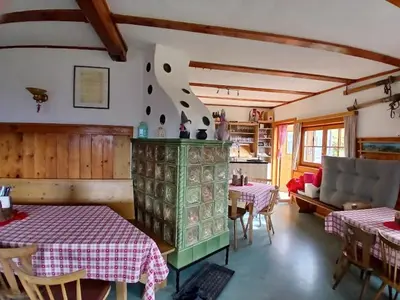 a dining room with two tables and a couch at Hühnerspielhütte - Rifugio Gallina - Mountain Hut Hühnerspielhütte in Moncucco