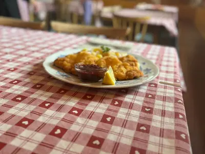 a plate of food on a red and white table cloth at Hühnerspielhütte - Rifugio Gallina - Mountain Hut Hühnerspielhütte in Moncucco