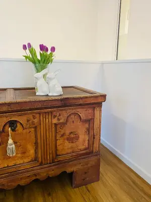 a wooden table with a vase of purple flowers on it at Amort Suites Meran in Merano