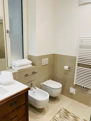 a bathroom with a toilet and a sink and a mirror at Amort Suites Meran in Merano