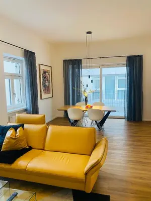 a living room with a yellow couch and a table at Amort Suites Meran in Merano