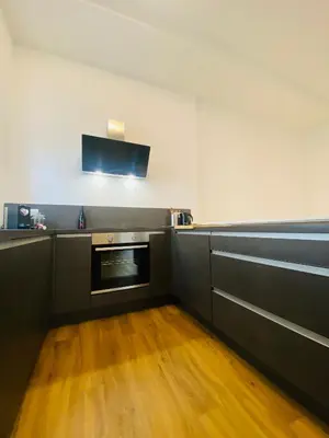 a kitchen with black counters and a stove at Amort Suites Meran in Merano