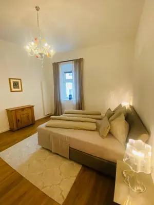 a bedroom with two beds and a chandelier at Amort Suites Meran in Merano