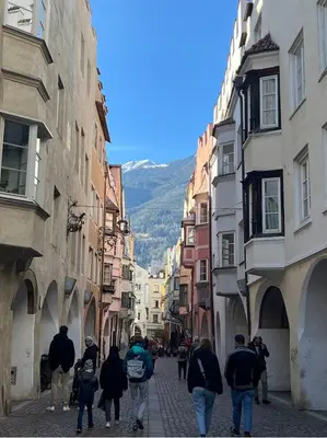 a group of people walking down a street between buildings at Vista Dolomiti in Bressanone