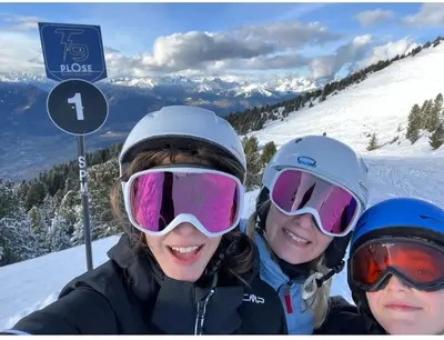 three women are posing for a picture on a ski slope at Vista Dolomiti in Bressanone