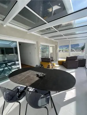 a living room with a black table and chairs at Vista Dolomiti in Bressanone