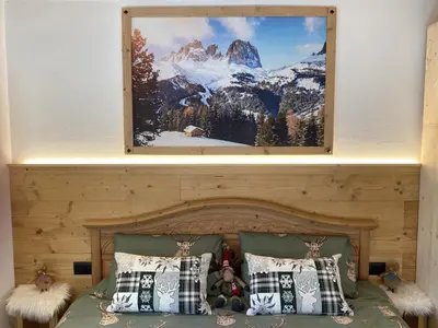 a bedroom with a bed with a picture on the wall at Ai Vòlti in Cavalese