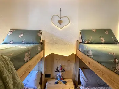a bedroom with two bunk beds and a heart on the wall at Ai Vòlti in Cavalese