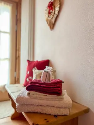 a pile of towels on a table in a room at B&B Profumi nel bosco in Carano
