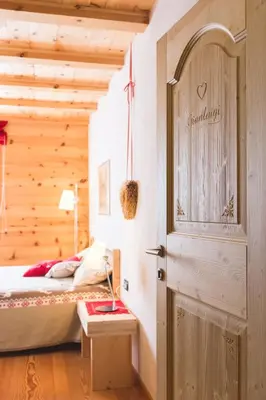 a bedroom with a bed and a door with a sign at B&B Profumi nel bosco in Carano