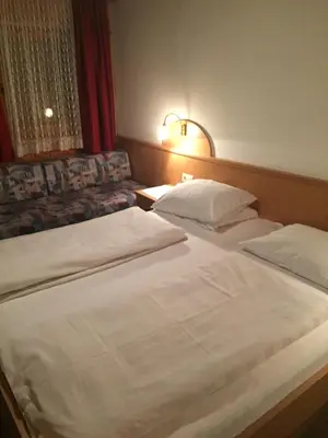 two beds in a hotel room with at Pension Aichner in Terento