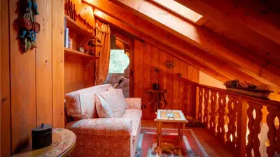 a room with a chair and a table in a cabin at Elegante Attico a San Vito in San Vito di Cadore