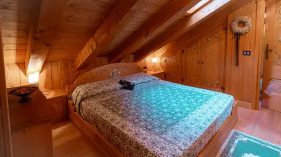a bedroom with a bed in a wooden cabin at Elegante Attico a San Vito in San Vito di Cadore