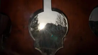 a person looking at the sun through a window at Elegante Attico a San Vito in San Vito di Cadore