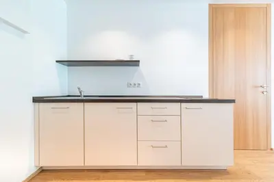 a kitchen with white cabinets and a black counter top at Apartments Greva 2 in Santa Cristina in Val Gardena
