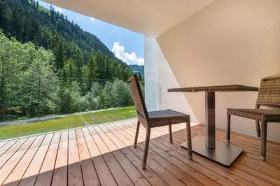 two chairs and a table on a deck with a view at Apartments Greva 2 in Santa Cristina in Val Gardena