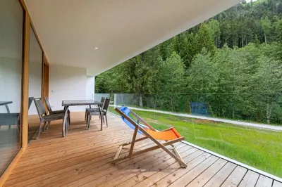 a room with a deck with a table and chairs at Apartments Greva 2 in Santa Cristina in Val Gardena