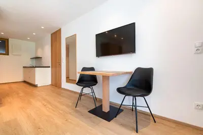 a table with two chairs and a television on a wall at Apartments Greva 2 in Santa Cristina in Val Gardena