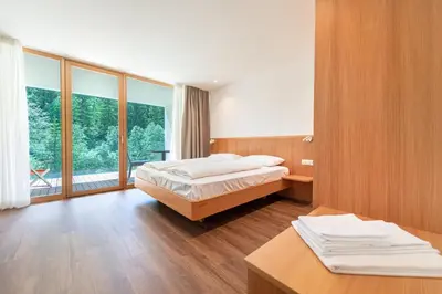 a bedroom with a bed and a large window at Apartments Greva 2 in Santa Cristina in Val Gardena