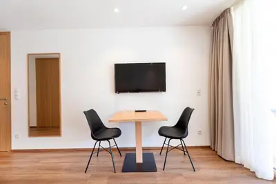 a table and chairs in a room with a tv at Apartments Greva 2 in Santa Cristina in Val Gardena