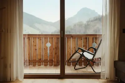 a balcony of a house with a table and chairs at Ciasa Linde in Longega