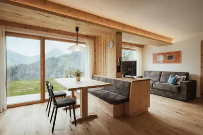 a living room with a television and a large window at Ciasa Linde in Longega