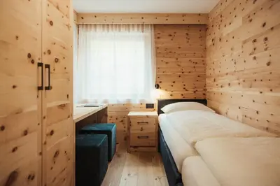 a white bathroom with a sink and a mirror at Ciasa Linde in Longega