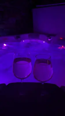 two wine glasses sitting in front of a swimming pool at Rabensteinhof - Urlaub auf dem Bauernhof in Parcines