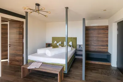 a bedroom with a bed with a mirror and a table at NoAN Panorama Suiten - D i c k e n s in San Genesio Atesino