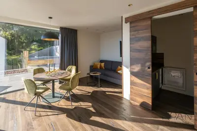 a living room with a table and chairs and a couch at NoAN Panorama Suiten - D i c k e n s in San Genesio Atesino