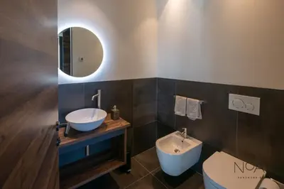 a bathroom with a sink and a toilet and a mirror at NoAN Panorama Suiten - D i c k e n s in San Genesio Atesino