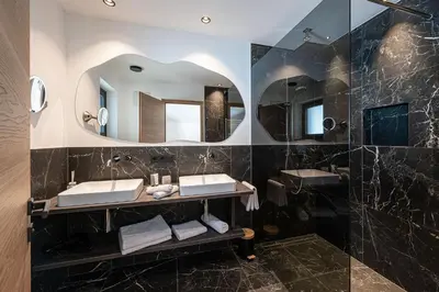 a bathroom with two sinks and a mirror at Krahof Dolomites - Urlaub auf dem Bauernhof in Castelrotto