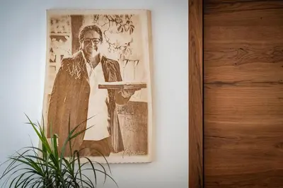 a picture of a man holding a tray on a wall at Krahof Dolomites - Urlaub auf dem Bauernhof in Castelrotto