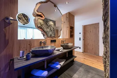 a bathroom with a sink and a large mirror at Krahof Dolomites - Urlaub auf dem Bauernhof in Castelrotto