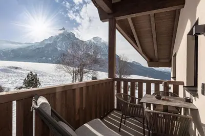 a balcony with a table and chairs and a view of a mountain at Krahof Dolomites - Urlaub auf dem Bauernhof in Castelrotto