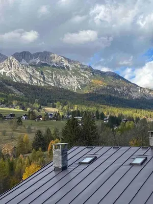 a large room with two beds and a table at Mansardina Mery Cortina - Studio - in Cortina dʼAmpezzo