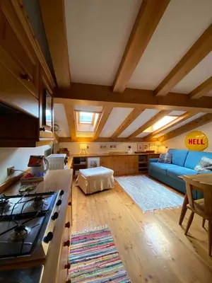 a kitchen with wooden cabinets and a sink and a stove at Mansardina Mery Cortina - Studio - in Cortina dʼAmpezzo